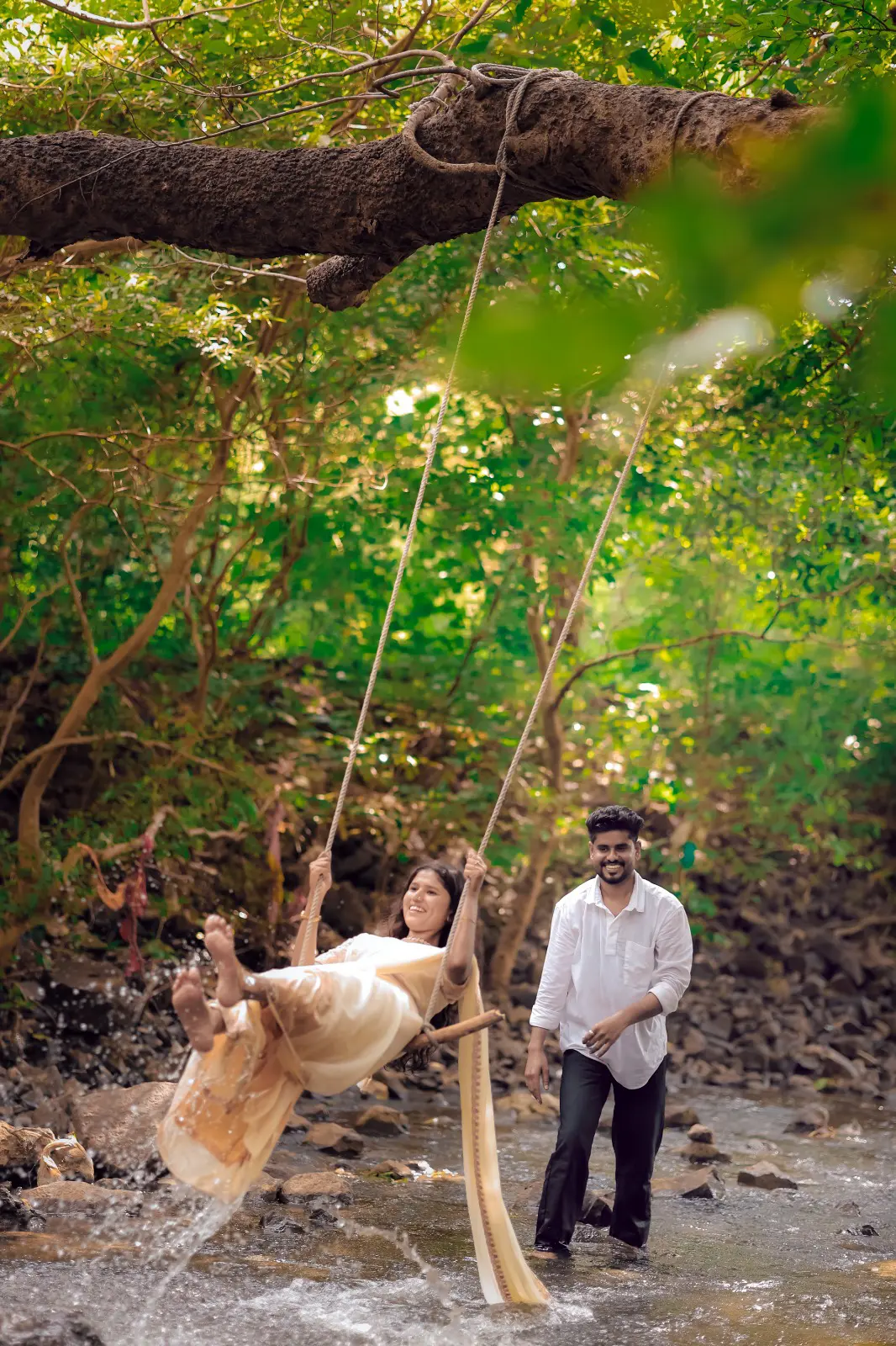 Couple on a swing in a forest stream