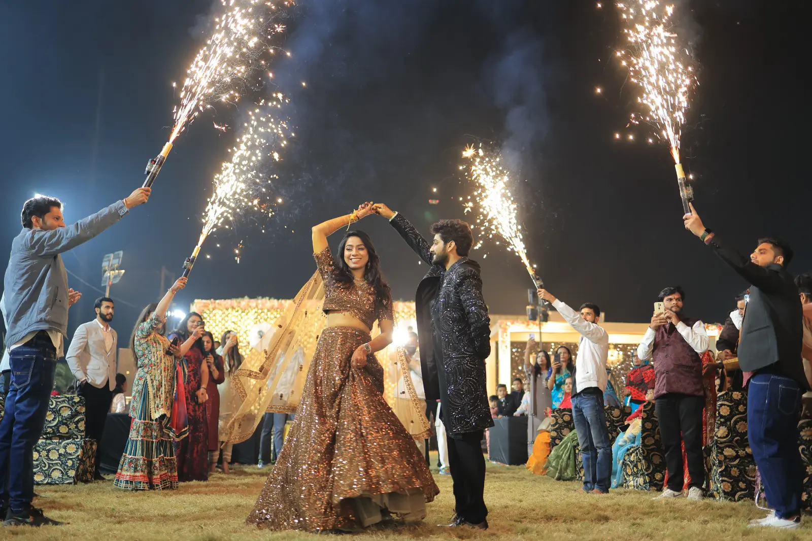 Couple dancing among sparklers at night